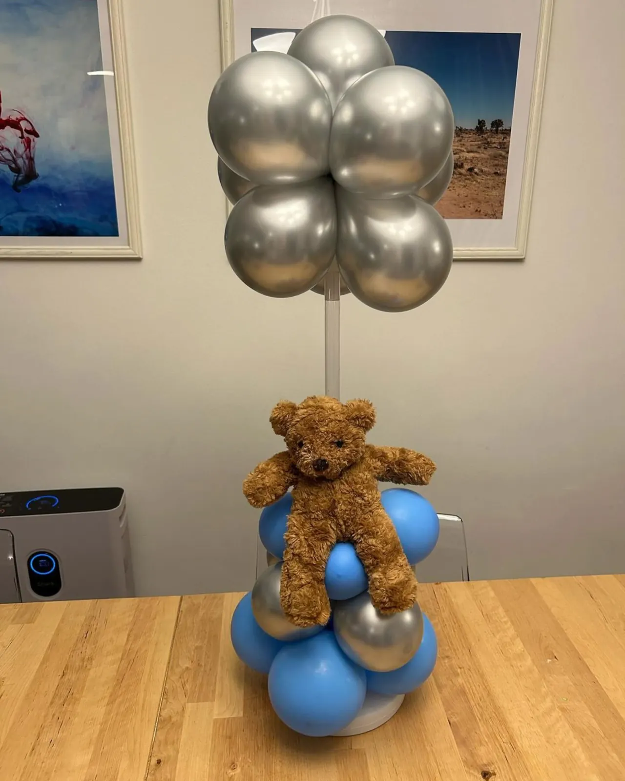 Silver and blue balloon centerpiece with a teddy bear