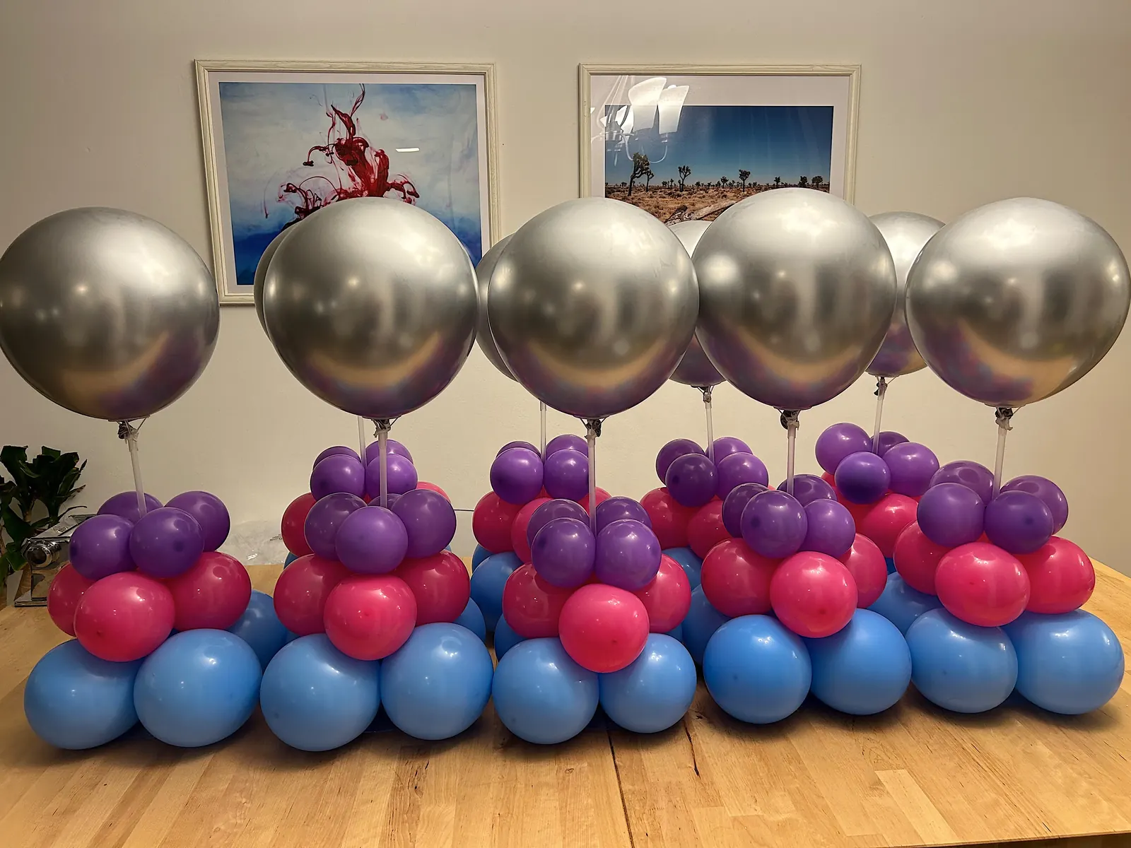 Set of centerpieces with silver balloons over pink, purple and blue bases