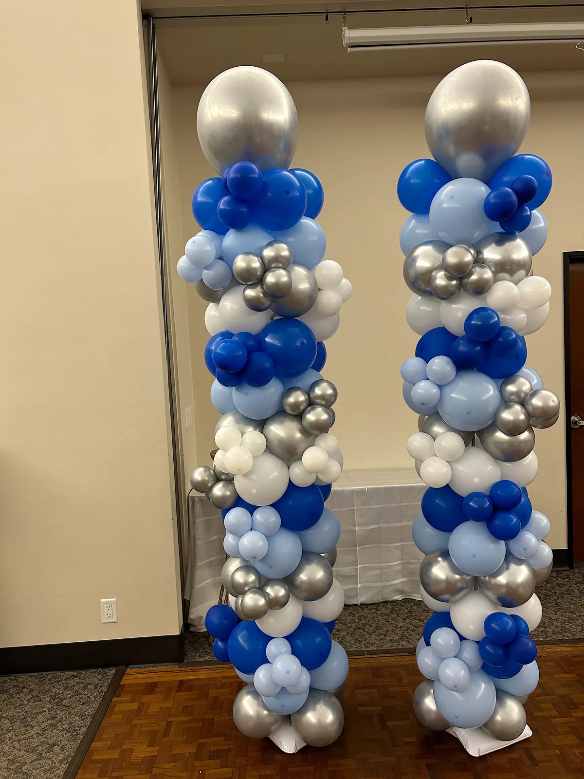 Two balloon columns in royal blue, light blue, silver and white at a Los Angeles event