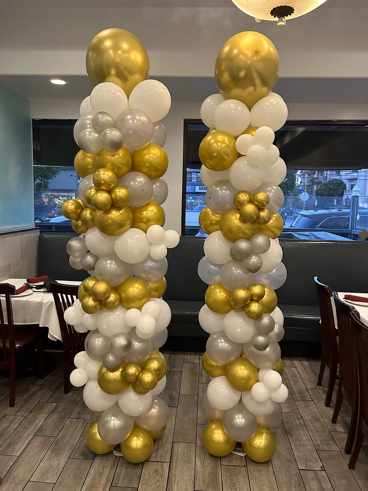 Pair of gold, silver and white balloon columns in a restaurant