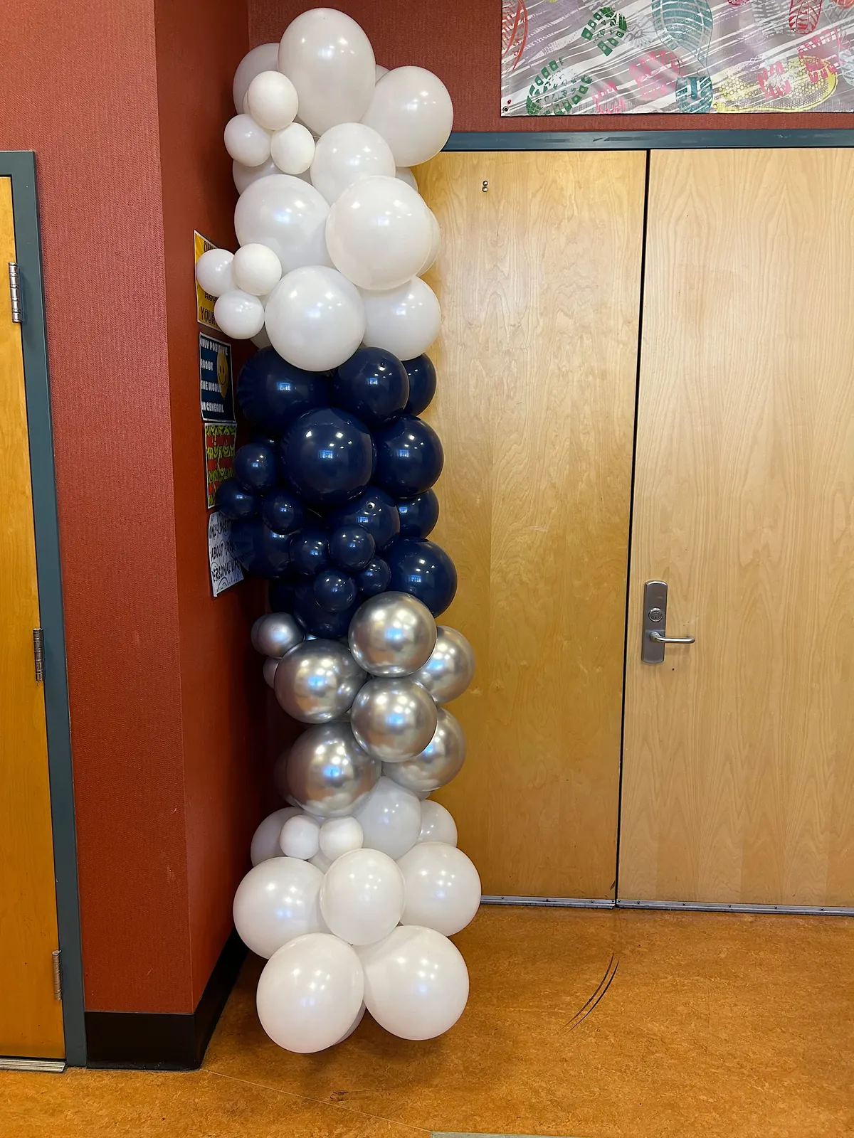 Navy, silver and white balloon garland running up a doorway