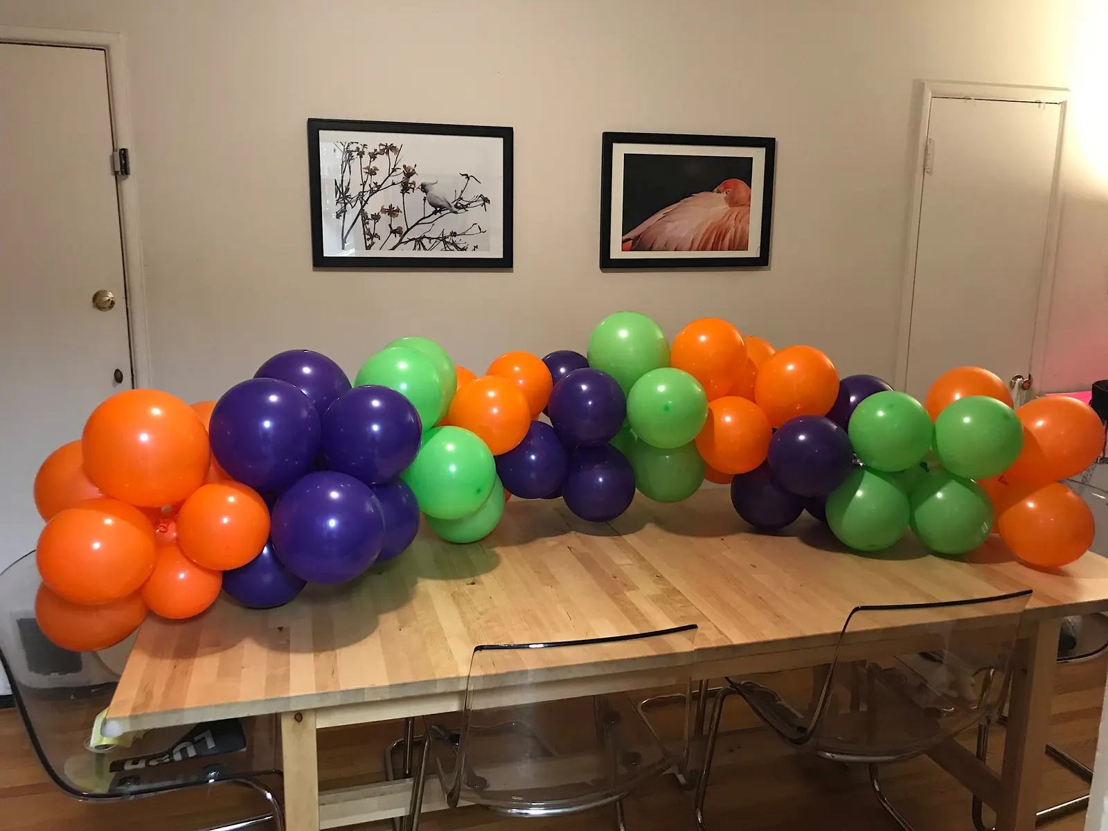 Orange, purple and green balloon garland along a dining table
