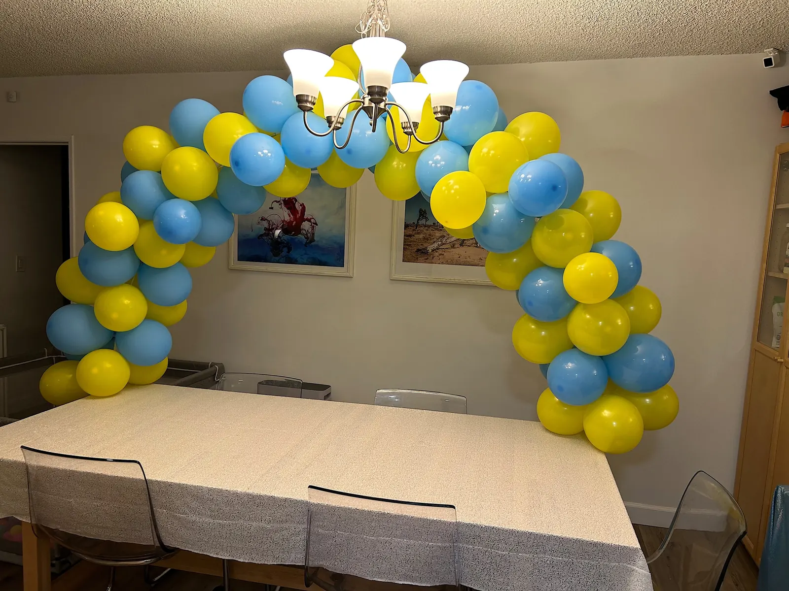 Blue and yellow table balloon arch over a dining table at a Los Angeles home