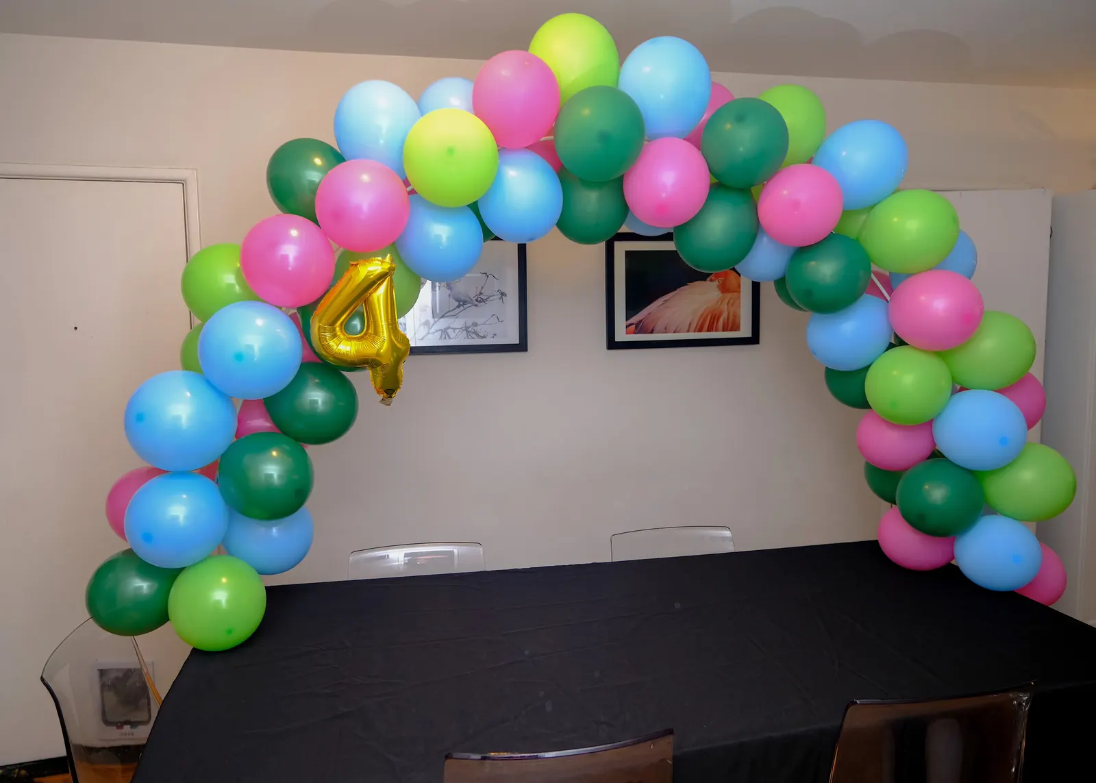 Green, pink and blue table balloon arch with a number 4 balloon